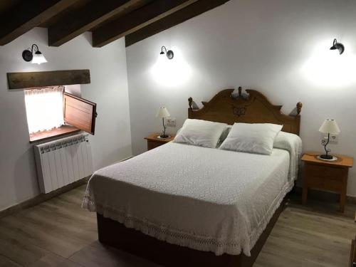 a bedroom with a bed and two lamps and a fireplace at Apartamento rustico en el Valle de Trapaga la Arboleda in La Arboleda