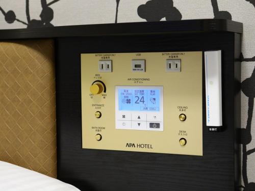 a tablet screen with a clock on a wall at APA Hotel Fukuoka Tenjin Nishi in Fukuoka
