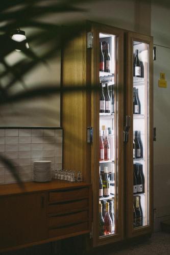 an open refrigerator filled with lots of bottles of alcohol at Hôtel Des Arts-Bastille in Paris