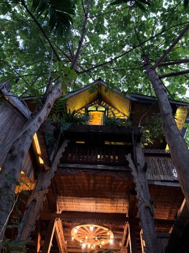 a tree house in the forest with lights at BaanBooLoo Village in Chiang Mai