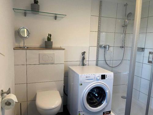 y baño con lavadora y aseo. en Ferienhaus Woidzauber, en Freyung