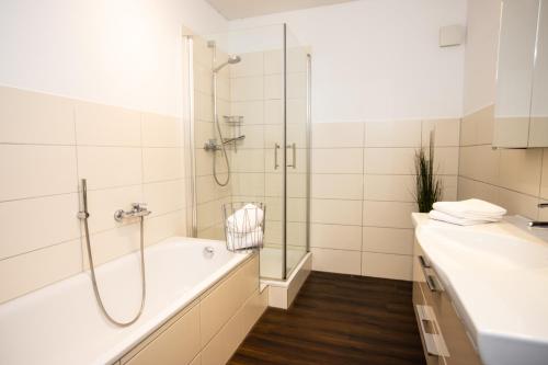 a bathroom with a shower and a tub and a sink at Moderne 2-Zimmer Wohnung! WLAN und Netflix inklusive! Zentral gelegen in der historischen Altstadt! in Stade