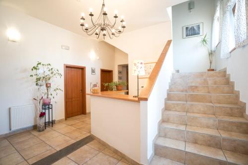 a staircase in a home with a chandelier at Penzion Grado Davle in Davle
