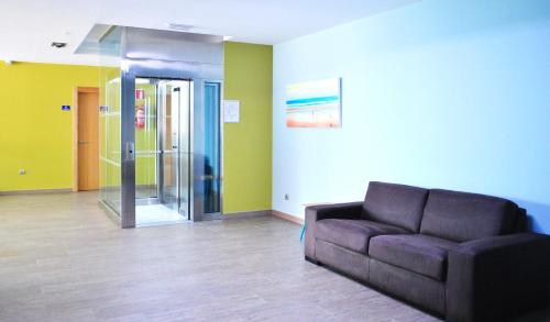 a living room with a couch and a glass door at Apartamentos Regollera in Noja