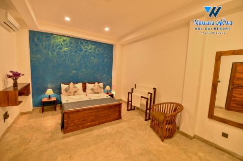 a bedroom with a bed and a blue wall at Nuwara Wewa Holiday Resort in Anuradhapura