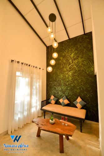 a living room with a couch and a table at Nuwara Wewa Holiday Resort in Anuradhapura