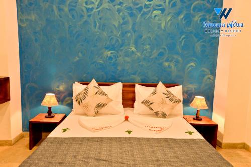 a bedroom with a bed with two lamps on two tables at Nuwara Wewa Holiday Resort in Anuradhapura