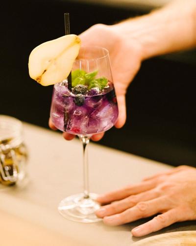 a person holding a wine glass with a banana on it at Venediger Lodge in Neukirchen am Großvenediger