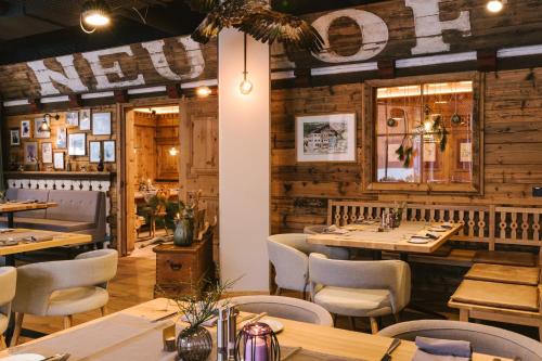 a restaurant with wooden walls and tables and chairs at Venediger Lodge in Neukirchen am Großvenediger