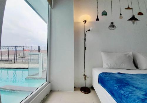 a bedroom with a bed next to a swimming pool at X-pressbedroom Vivo-Jogja in Seturan