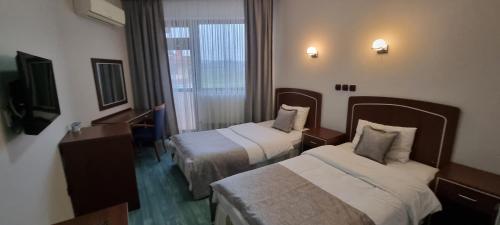 Ένα ή περισσότερα κρεβάτια σε δωμάτιο στο Flora Hotel