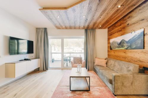 a living room with a couch and a tv at Venediger Lodge in Neukirchen am Großvenediger