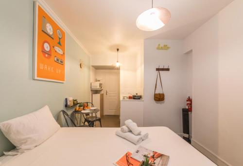 - une chambre avec un lit blanc et une photo orange dans l'établissement WS Montmartre - Sacré Coeur, à Paris