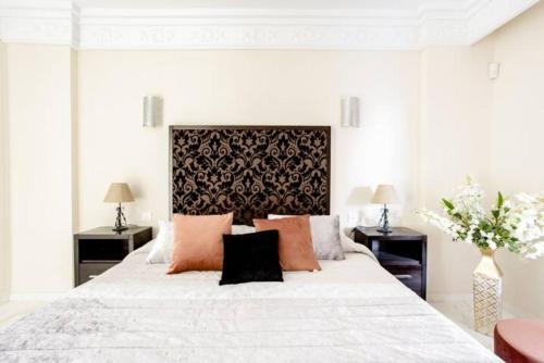 ein weißes Schlafzimmer mit einem großen weißen Bett und orangefarbenen Kissen in der Unterkunft New Apartment Sherezade Tenerife in Puerto de la Cruz