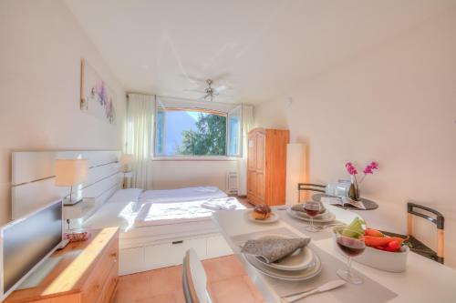a kitchen with a table with plates and fruit on it at Cortivo Apartments in Castagnola