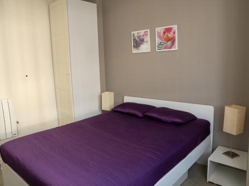 a bedroom with a purple bed with two purple pillows at Appartement Mont Dore face aux Thermes - Centre in Le Mont-Dore