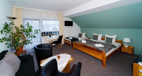 pokój hotelowy z 2 łóżkami, stołem i krzesłami w obiekcie Bestwaner Hotel w mieście Bestensee