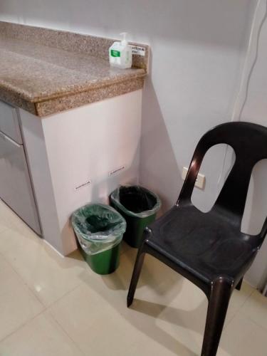 a chair sitting next to two trash cans next to a counter at V.F. Riton Apartelle in Laoag