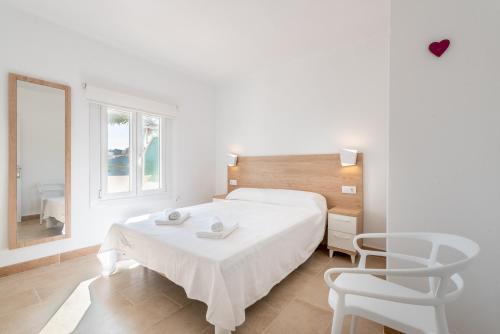 biała sypialnia z łóżkiem i 2 krzesłami w obiekcie Apartment Sa Caseta 2 by Mallorca House Rent w mieście Portopetro