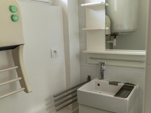 a white bathroom with a sink and a mirror at Appartement Mont Dore face aux Thermes - Centre in Le Mont-Dore