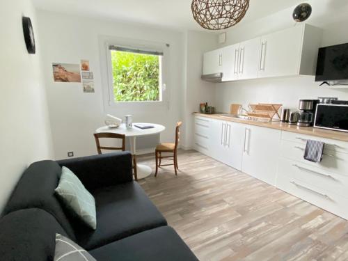 a living room with a couch and a kitchen at Résidence des 3 îles, en plein centre-ville, à 5 min des plages, 3 appartements neufs in Étables-sur-Mer
