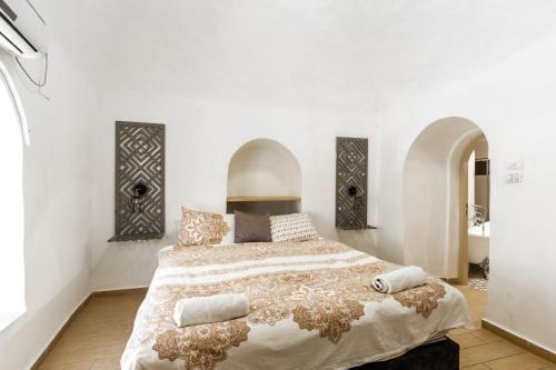 una camera da letto con un grande letto e pareti bianche di Private House 5 BDR In Mamilla up to 12 People ! a Gerusalemme