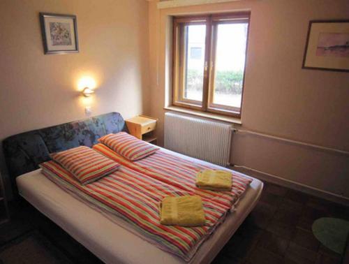 a bedroom with a bed with two pillows and a window at Family Home, Bohinj - Bled in Bohinj