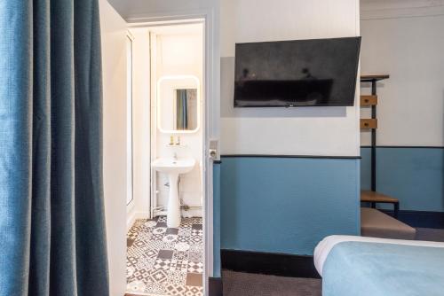 a bathroom with a sink and a toilet in a room at Lennon by Avalon Hotel Paris Gare du Nord in Paris
