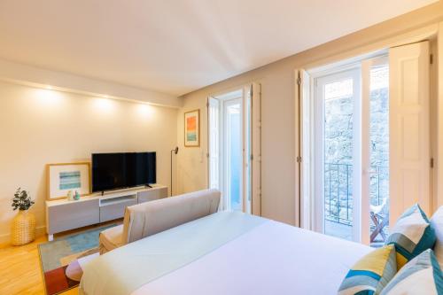 a bedroom with a large bed and a television at Clérigos Tower - Experience in Porto in Porto