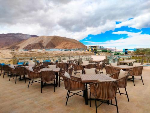 a restaurant with tables and chairs with a mountain in the background at Eastern El-Galala Aquapark Ain Sokhna in Ain Sokhna