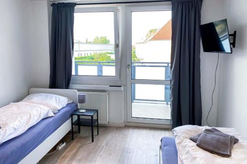 a bedroom with two beds and a large window at Work & Stay Apartment in Bitterfeld