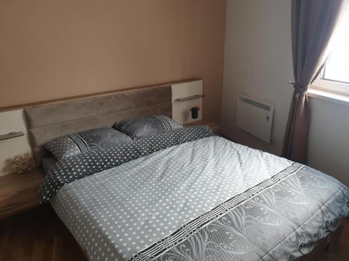 a bedroom with a large bed with a window at Apartman Noalux 2 Kopaonik in Kopaonik