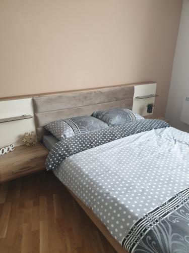 a bedroom with a large bed with a wooden headboard at Apartman Noalux 2 Kopaonik in Kopaonik