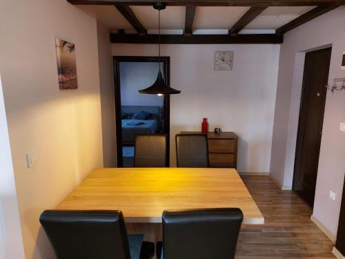 a dining room with a wooden table and chairs at Apartments Vukalovic in Medulin