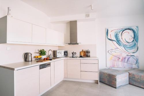 eine Küche mit weißen Schränken und einem Wandgemälde in der Unterkunft Apartament Blue Sky in Hel