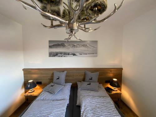 オーバーロイテにあるFerienwohnung Hochgratglückのベッド2台とシャンデリアのある寝室