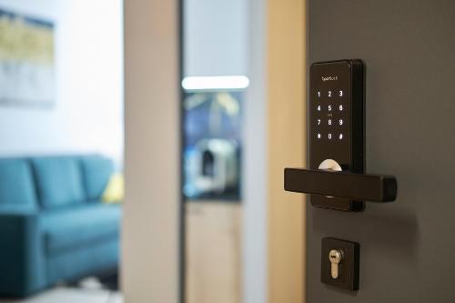 a remote control on a door with a blue couch at Green Ande in Wrocław