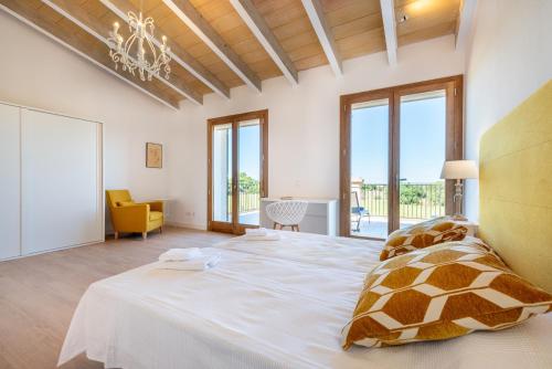 ein Schlafzimmer mit einem großen Bett mit Kronleuchter in der Unterkunft Finca Sa Era by Mallorca House Rent in Felanitx