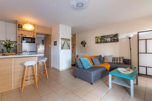 un salon et une cuisine avec un canapé et une table dans l'établissement MELCHIOR - Beau T2 avec terrasse au cœur d'Euroméditerranée, à Marseille