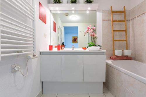 La salle de bains blanche est pourvue d'un lavabo, d'une baignoire et d'une chambre. dans l'établissement MELCHIOR - Beau T2 avec terrasse au cœur d'Euroméditerranée, à Marseille