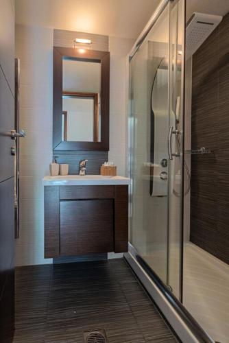 a bathroom with a sink and a shower with a mirror at Villa Ellovos with Private Pool in Rethymno Town