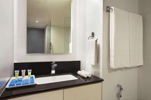 a bathroom with a sink and a mirror at Days Inn & Suites by Wyndham Bengaluru Whitefield in Bengaluru