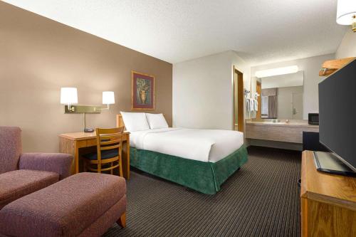 um quarto de hotel com uma cama e uma televisão em Travelodge by Wyndham Wellington em Wellington