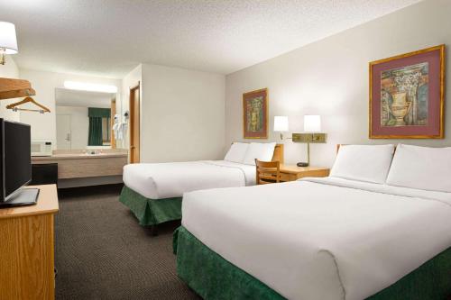 a hotel room with two beds and a television at Travelodge by Wyndham Wellington in Wellington
