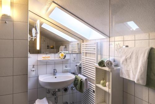 een badkamer met een wastafel en een spiegel bij Landhaus Gschwand in Krün