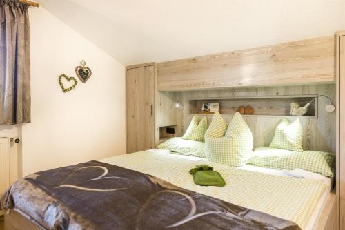 a bedroom with a large bed with a green towel on it at Landhaus Gschwand in Krün