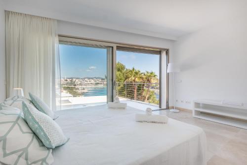 Biały salon z dużym szklanym oknem w obiekcie Villa Es Falcons w Porto Cristo
