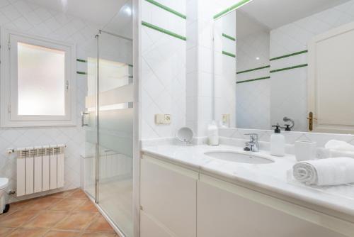 une salle de bain blanche avec lavabo et douche dans l'établissement Villa Front a Far, à Portocolom