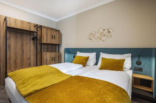 a bedroom with a large bed with a yellow blanket at Apart of me Klagenfurt in Klagenfurt