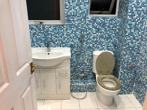 a bathroom with a toilet and a sink at Nice 3-Bed House in Farnham Royal Slough in Slough